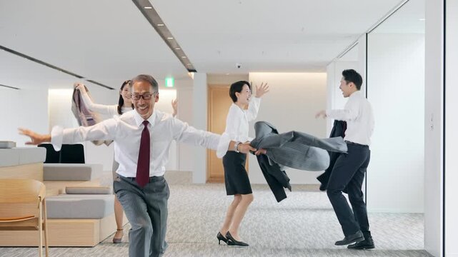 オフィスでダンスするビジネスパーソンのグループ