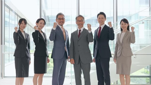 オフィスでガッツポーズするビジネスパーソンのグループ