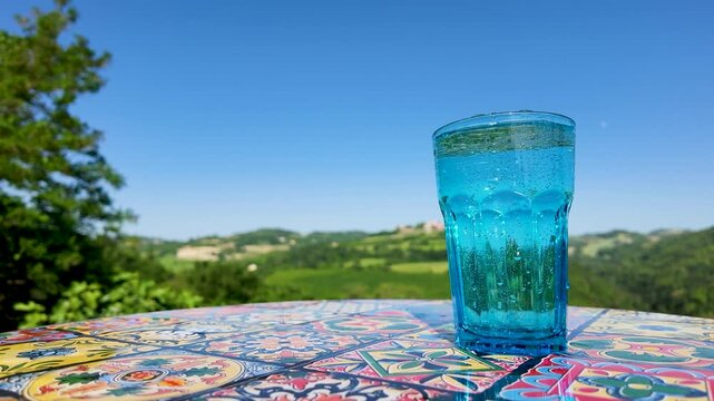 Sparkling Mineral Water in Blue Glass on Scenic Outdoor Table