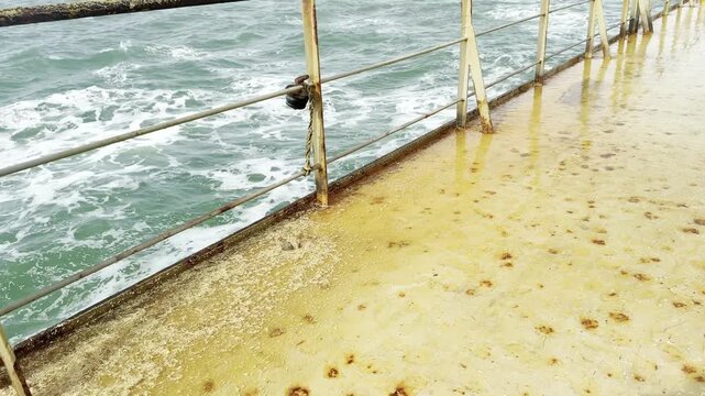 wheat cargo residues washing from the ship deck to ocean via scupper.
