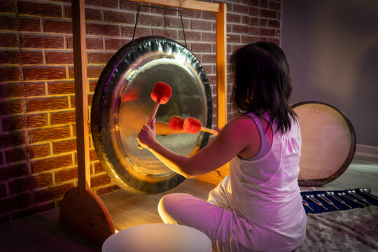young woman playing the gong