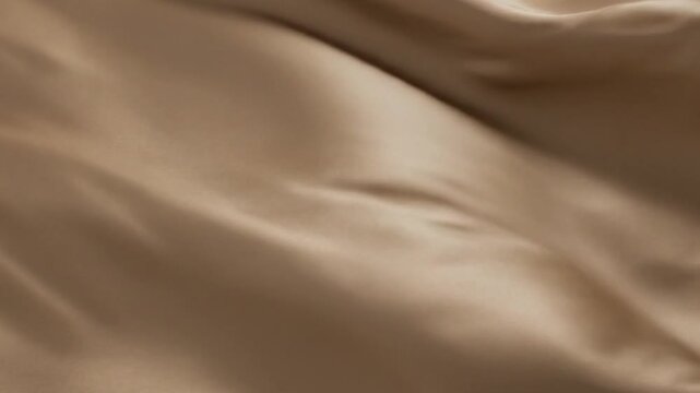 Close-up of flowing smooth satin fabric in a soft beige color with elegant drapes and gentle folds