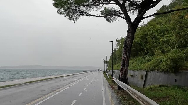 wet rain cycling bicycle riding in small village coastal town adriatic mediterranean sea slovenia piran puddle pedestrian seaside path travel storm rainy tunnel trail nature adventure tourism travel