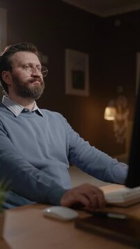 Male remote worker computer user in home office is thoughtfully waiting for something. Freelancer is waiting