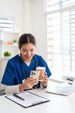 Female doctor using cell phone on coffee break at hospital.
