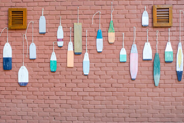 Decorative wooden lobster buoys on brick wall © HanThar Fusion