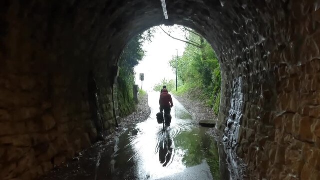 wet rain cycling bicycle riding in small village coastal town adriatic mediterranean sea slovenia piran puddle pedestrian seaside path travel storm rainy tunnel trail nature adventure tourism travel