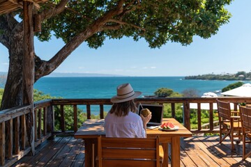 Obraz premium Remote work woman with laptop on sunny terrace overlooking tropical ocean view