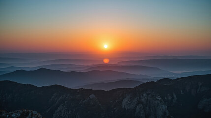 Obraz premium Sunrise mountain layers horizon glowing serene light mist