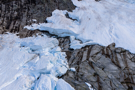 Blue Glacier Ice And Jagged Rock Face On Alpine Slope In BC, Canada