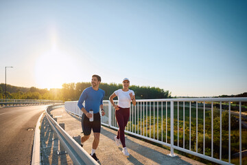 Naklejka premium Happy athletic couple enjoying in recreational running outdoors.