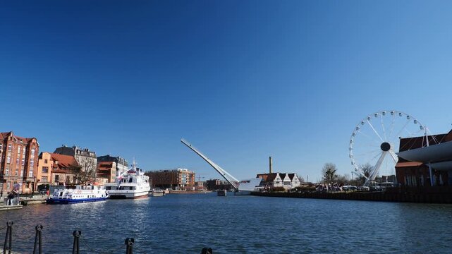 Ferris wheel, ferry boats and the bascule footbridge to Ołowianka closing down over the canal.