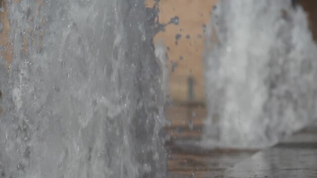 Super slow motion of waters jets installed on the floor of a square. Altamira palace square, Elche, Spain.