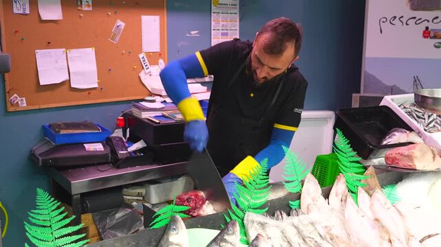 Professional male fishmonger cutting a large piece of fresh tuna with a cleaver at his market stand