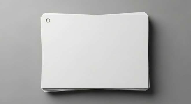 Stack of blank white index cards with a hole punch on a gray background