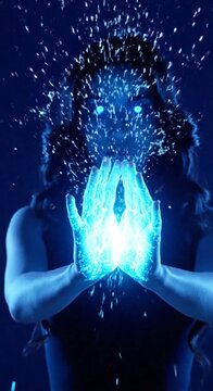 Mystical woman with glowing blue eyes and magical energy hands in dark atmosphere.