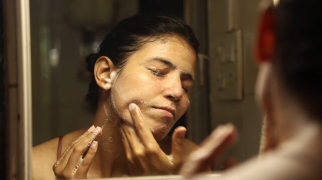 An Indian woman washing her face and doing her skin care routine in her 30s