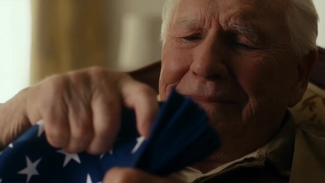 Elderly man folding American flag on july 4th independence day
