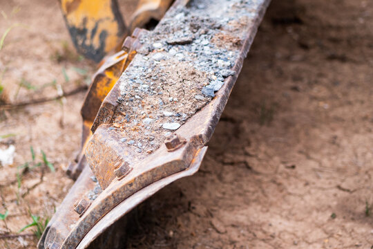 Heavy machinery attachment close-up construction site industrial equipment ground level detail focus