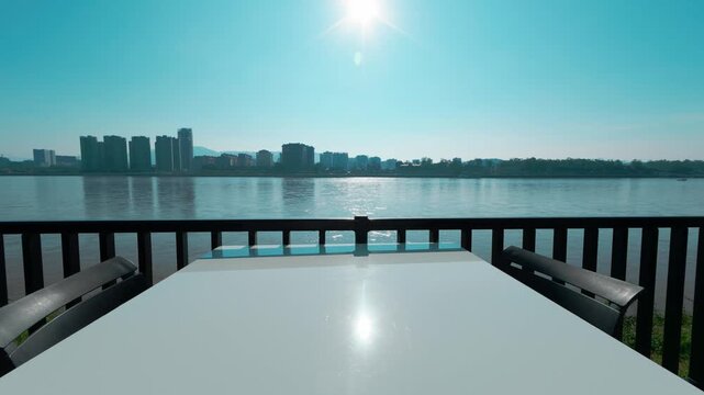 The view from the outdoor dining table overlooks the large Mekong River, with the opposite bank consisting of tall buildings belonging to Laos.