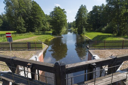 A wooden lock opens onto a quiet river surrounded by trees, Tartak Lock, Augustow Canal, Augustowski Canal, Suwałki, Podlaskie, Podlaskie, Poland