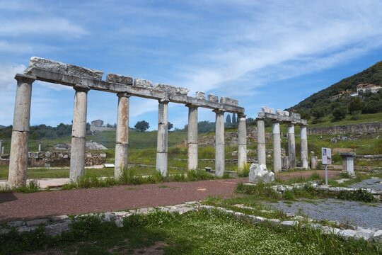 A row of ancient columns against a mountain backdrop bears witness to a bygone civilisation, Messene, ancient Greek polis, Messini, Messenia, Peloponnese, Greece