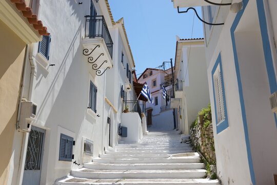 A sun-drenched alleyway with white houses and blue accents in Koroni, Pylos-Nestor, Messinia, Peloponnese, Greece