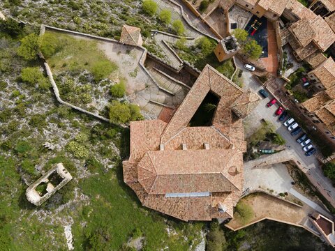 An aerial view of a historic fortress with tiled roofs and surrounding buildings on stony terrain, aerial view, collegiate church on the hill, Colegiata de Santa Mar&iacute;a la Mayor, Alqu&eacute;zar, Alquezar, Huesca, Arag&oacute;n, Aragon, Pyrenees, Spain