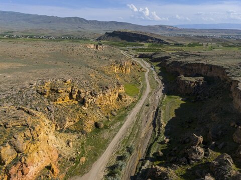 Narrow road leads through a rocky canyon with scattered green areas, aerial view, landscape at Angel's Canyon, canyon, Dashtakar, Ararat province, Armenia