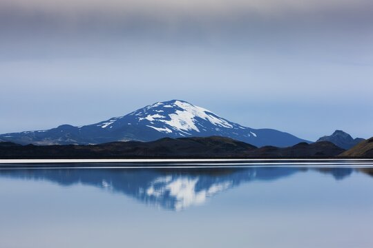 Reflection of the snow-covered volcanic cone Hekla in Hrauneyjalon, South Iceland, Iceland
