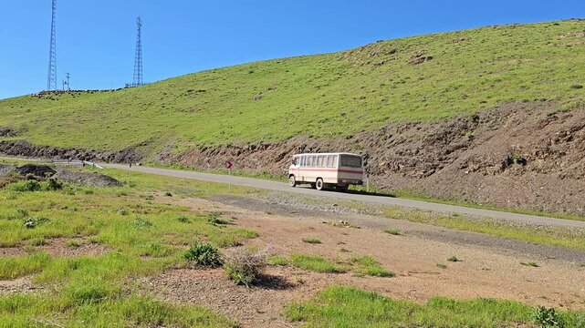 Lush green rolling hills under bright blue sky with a minibus on a winding mountain road through a scenic landscape.
📍 Marivan, Kurdistan, Iran 