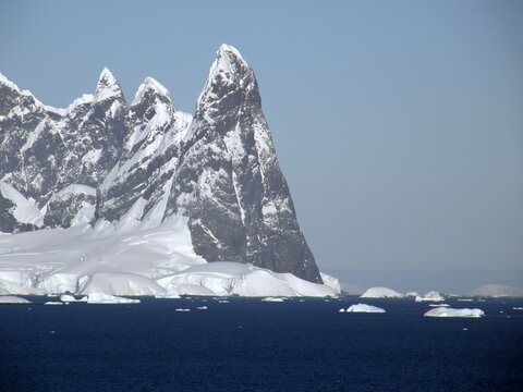 spectacularly steep Antarctica peaks and icebergs on a sunny summer day in the neumayer channel in the palmer archipelago in northern antarctica