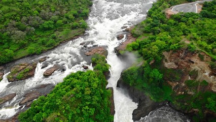 Naklejka premium Aerial View Of Rocky Cascade, Overhead Perspective Of Waterfall With Surrounding Greenery And Mist. Media
