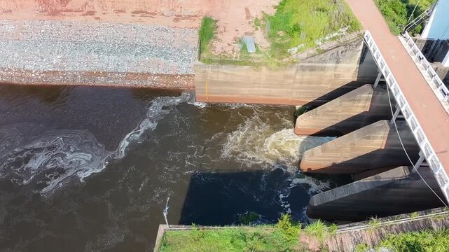 dam on the river, water rushing through concrete dam spillway gates, generating strong currents and white foam for agricultural irrigation management concept