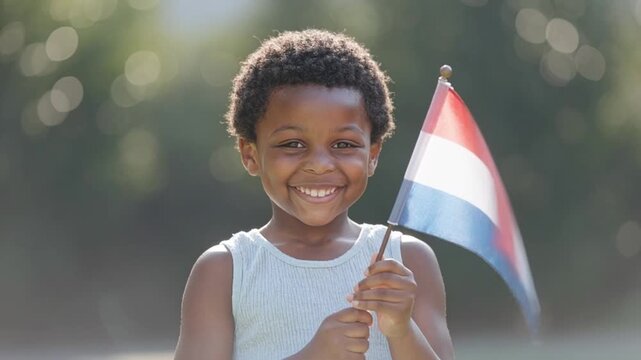 Juneteenth child holding small freedom flag in bright summer sunlight for hopeful heritage education and family media