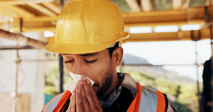Architect, sick or man blowing nose with tissue for influenza, disease or virus on construction site. Male person, contractor or civil engineer with cold or flu symptom for hayfever, sinus or allergy