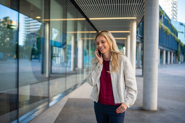 Fototapeta premium Happy business woman talking on phone outdoors concept