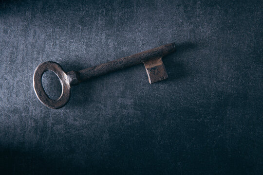 Old key on a black background. Selective focus. Toned.