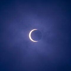 Obraz premium Partial Solar Eclipse Crescent Sun Against Deep Blue Sky