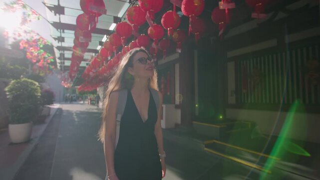 Tourist walking through the streets of Chinatown in Singapore city. Beautiful Chinese lanterns hanging on buildings, tourist architecture, travel in Asia