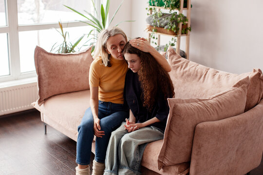 Mother Talking With Unhappy Teenage Daughter On Sofa, Mom supports a sad teen girl, mom and child together