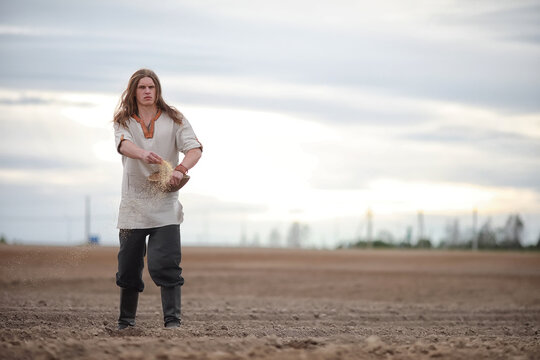 A young peasant sows the field with grain