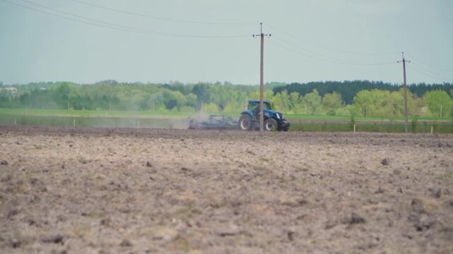 Blue Tractor Cultivating Agricultural Field on Rural Farmland