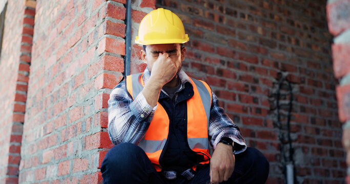 Civil engineer, stress and man with headache at construction site, thinking and architecture mistake. Unhappy, architect and person with migraine, contemplating and frustrated with project failure