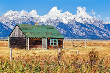 Old timber cottage on the prairie at Teton range a sunny autumn day © Lars Johansson