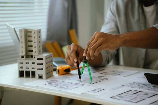 Architects are reviewing building plans, which reflect architectural design, construction planning, and real estate project development.