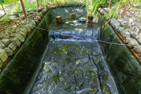 Ein leerer Gartenteich ges&auml;ubert vor dem Bef&uuml;llen