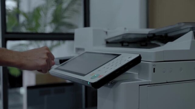 Hand using office copier machine.