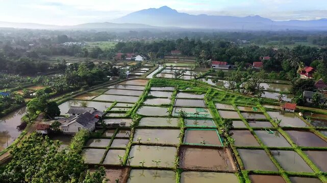 Aerial View of Indonesian Village with Fish Ponds and Mountains