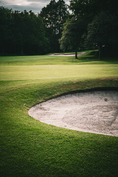 Golf course sand trap bunker with green grass fairway